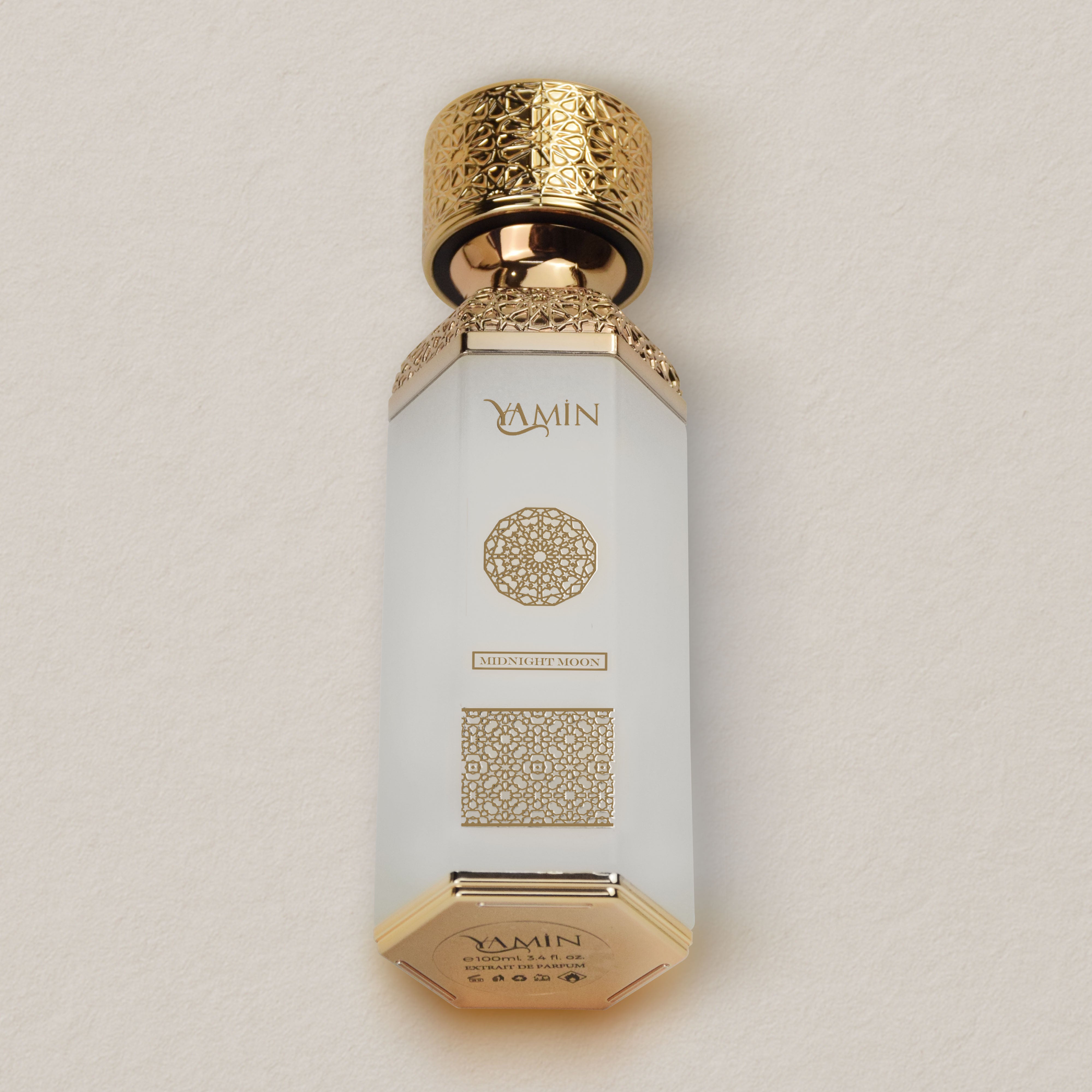YAMIN Midnight Moon bottle with gold cap and decorative design on a beige background