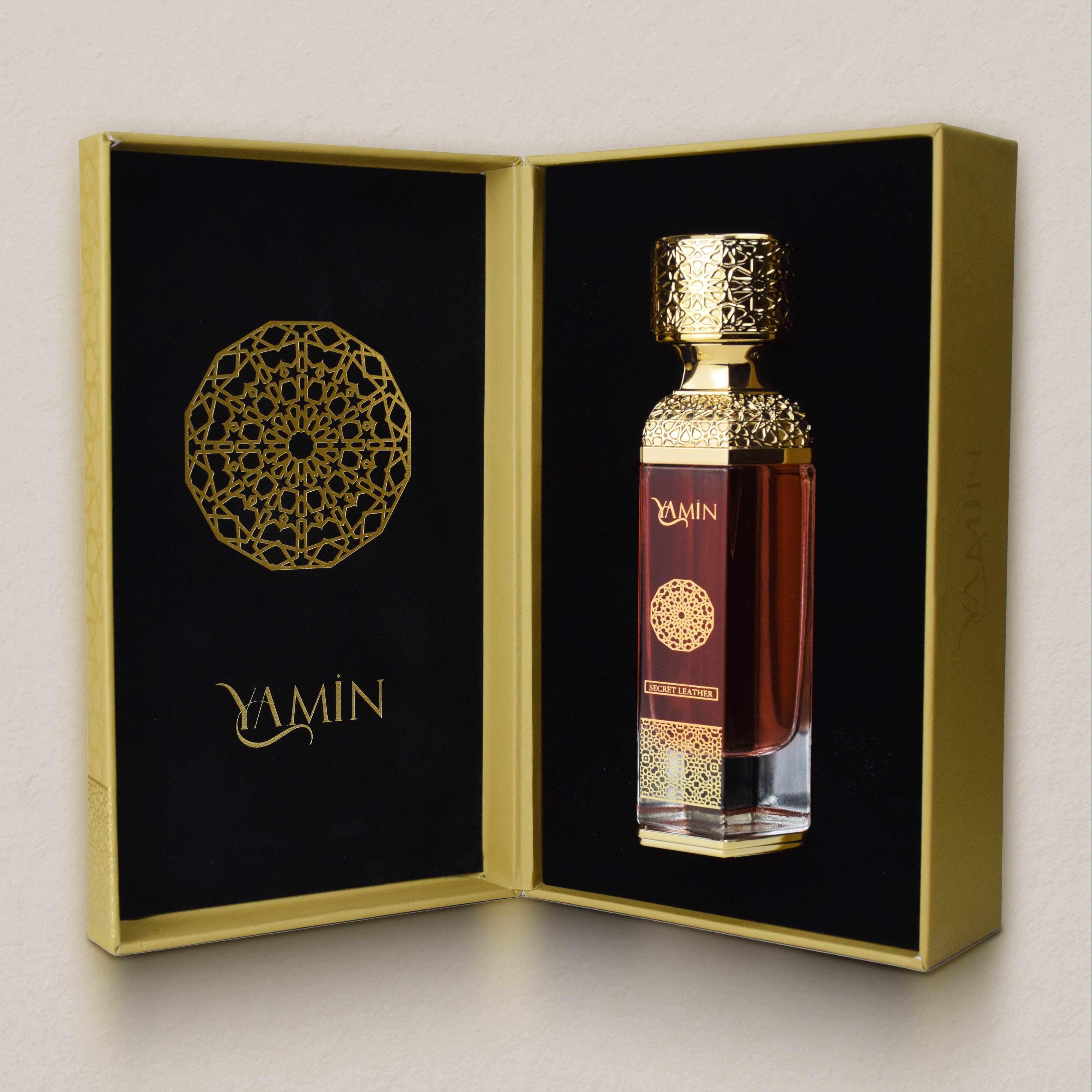 YAMIN Secret Leather perfume bottle in its black and gold packaging box on a light gray background
